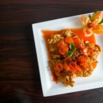 Gęsty sos z pieczonych pomidorów: smak lata zimą Chrupiący kurczak z marchewką i dekoracją z pomidora na talerzu