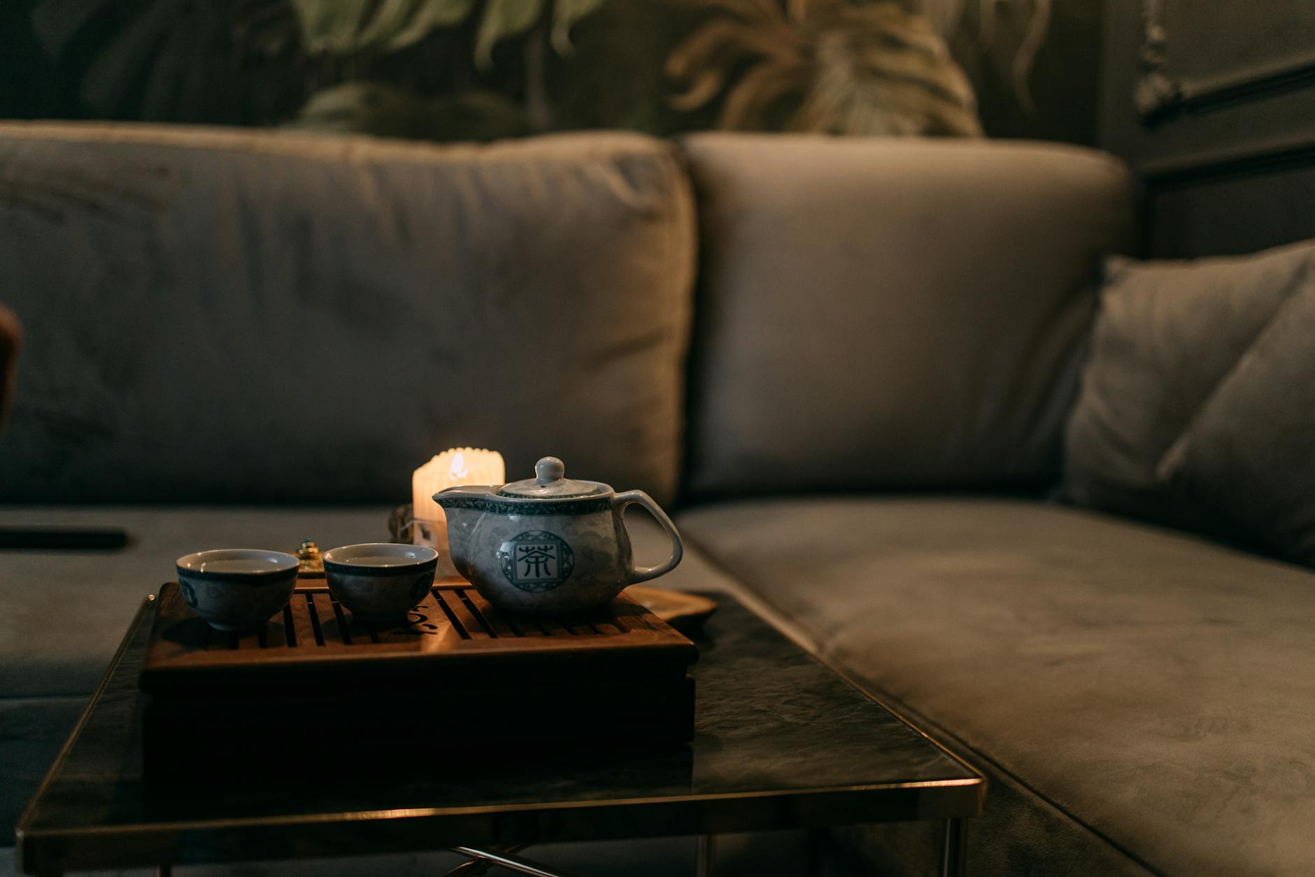 Czajnik i filiżanki na tacy przy świecach, wieczorna kolacja