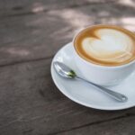 Latte z pianką i sercem z latte art na drewnianym stoliku