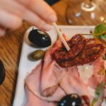 Włoska deska antipasti z szynką, oliwkami i suszonymi pomidorami