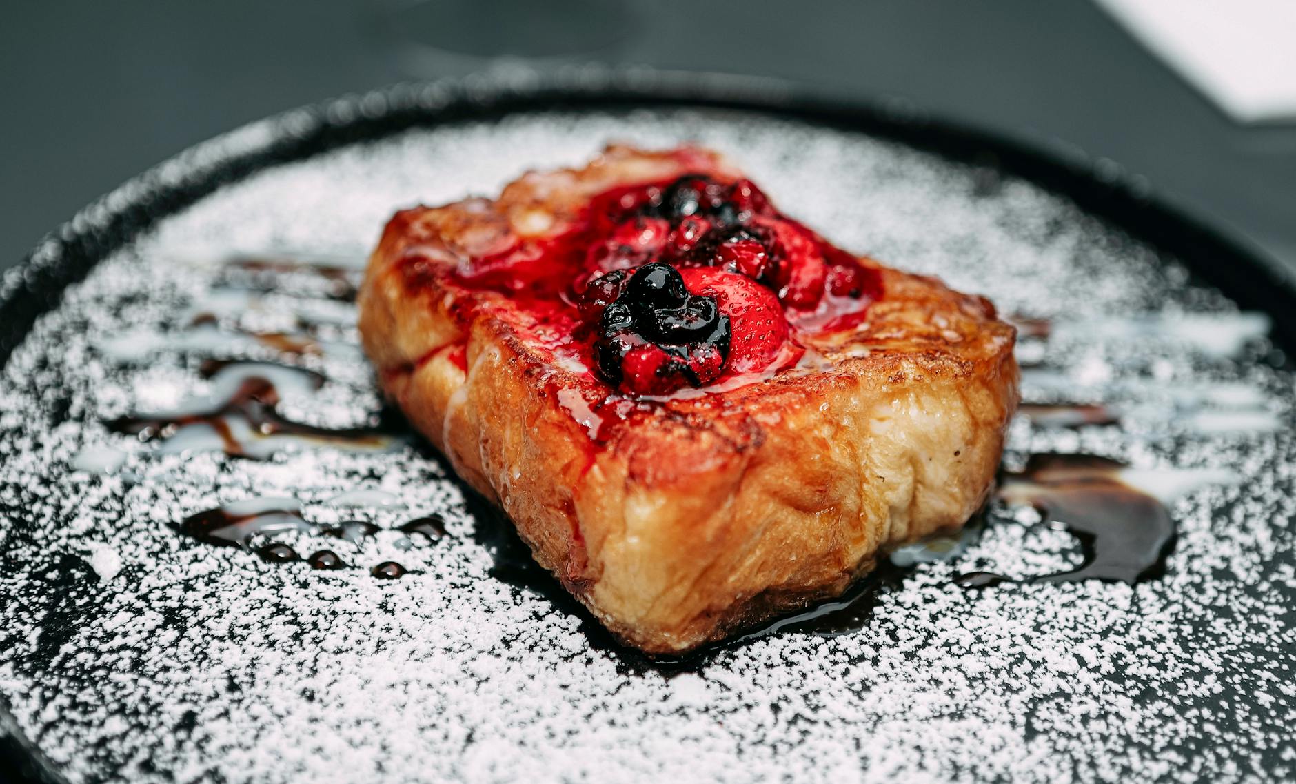 Francuskie tosty z cukrem pudrem i świeżymi jagodami na śniadanie