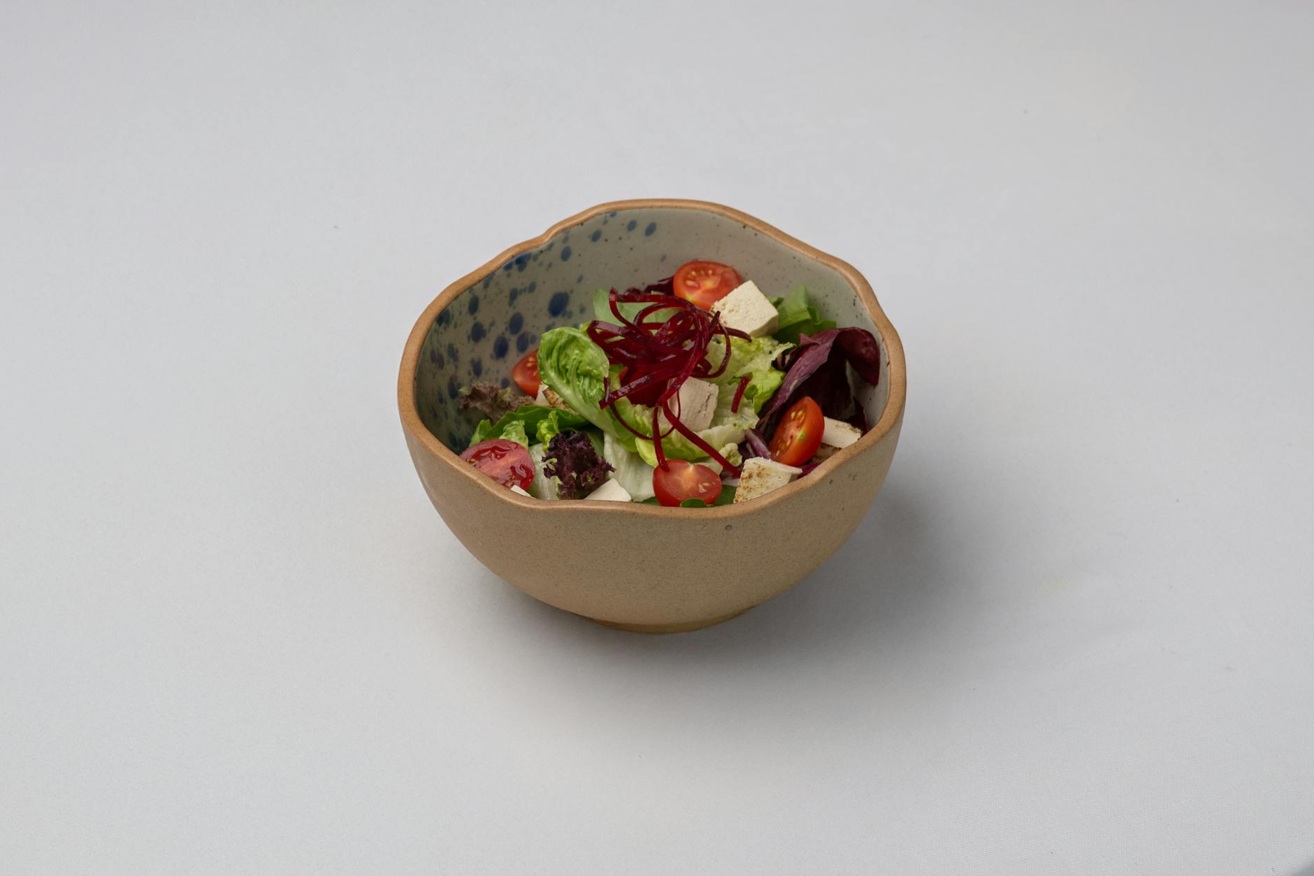 Miska sałatki z tofu, pomidorkami koktajlowymi i zielonymi liśćmi