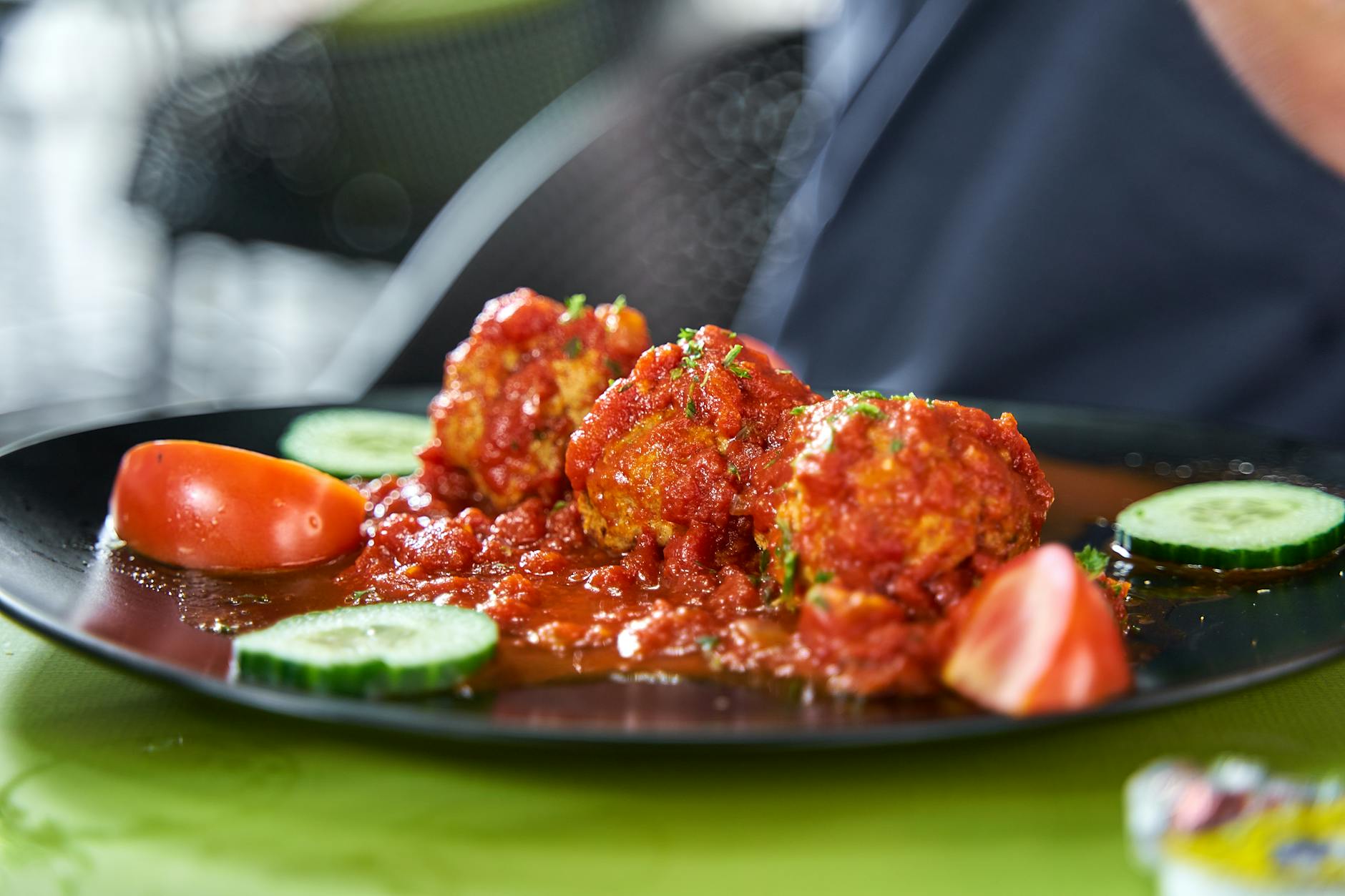 Talerz klopsików w gęstym sosie pomidorowym z ogórkiem i pomidorem