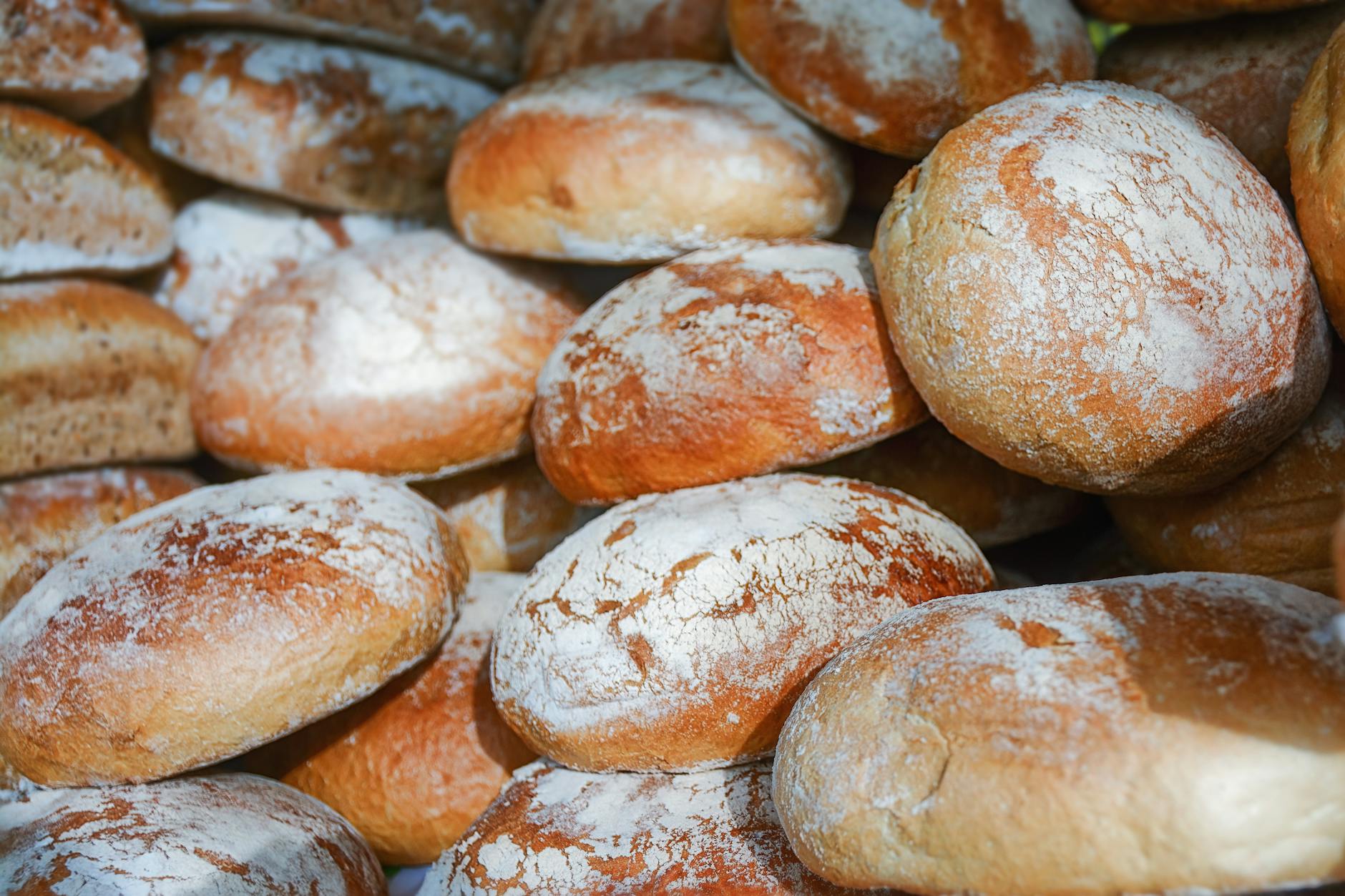 Zbliżenie na oprószone mąką bochenki rzemieślniczego chleba